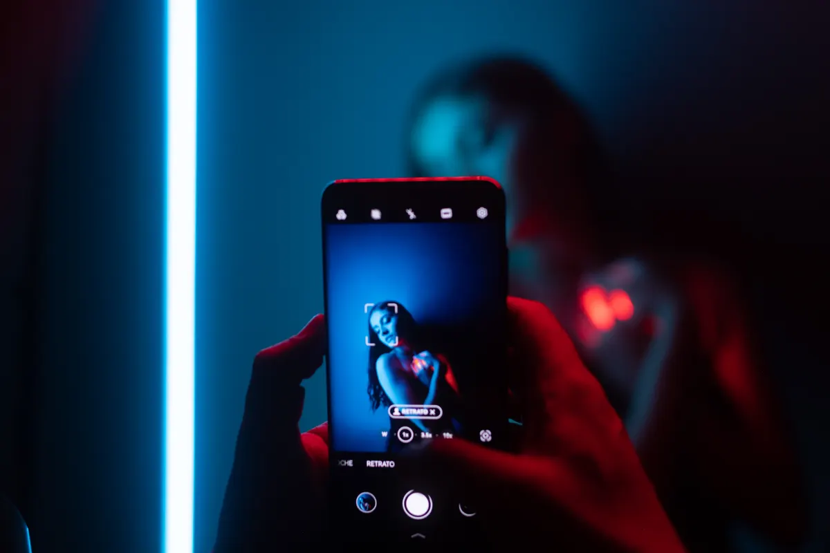 La pantalla de un teléfono grabando a alguien bajo una luz azul